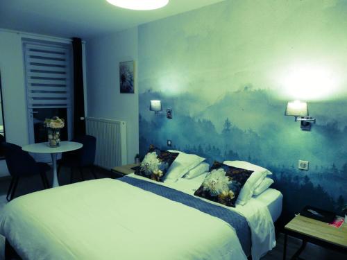a bedroom with two beds and a painting on the wall at Le 9 en Cuisine in Rabastens