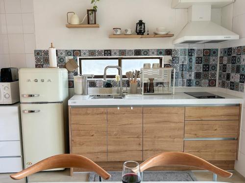 a kitchen with a white refrigerator and wooden cabinets at Blue Sands in Busan
