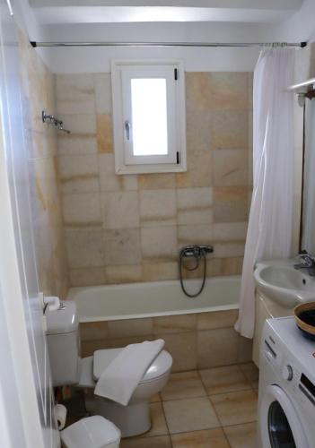 a bathroom with a toilet and a tub and a sink at Seaview Ampelas Studio in Ambelas