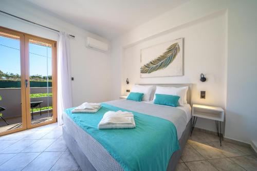 a white bedroom with a bed and a balcony at Vera Relaxo Villa, a Countryside Escape in Angeliana