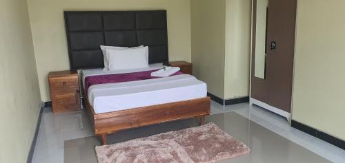 a bedroom with a bed and a mirror and a rug at NEBCON Executive Lodge in Kitwe