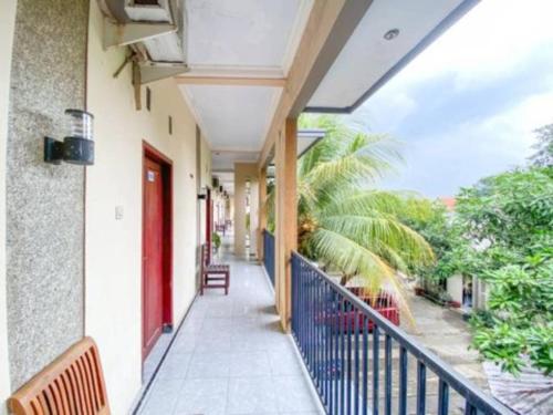 a balcony of a building with a red door at Surya Guest House in Kanigaran