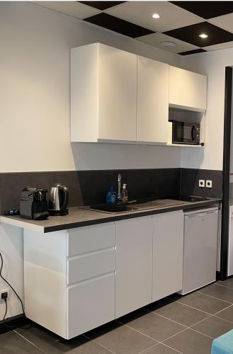 une cuisine avec des armoires blanches et un comptoir dans l'établissement Studio dans le centre de GAP, à Gap