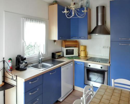 - une cuisine bleue avec évier et four micro-ondes dans l'établissement Maison conviviale avec vue sur la montagne à Sainte-Maxime, à Sainte-Maxime