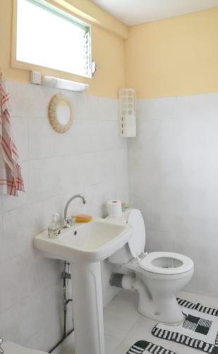 une salle de bain avec un lavabo blanc et des toilettes dans l'établissement Maison conviviale avec vue sur la montagne à Sainte-Maxime, à Sainte-Maxime