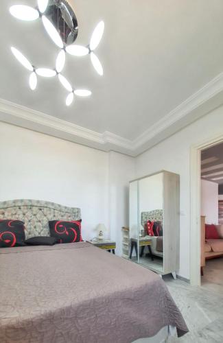 a bedroom with a bed and a ceiling fan at Comfortable Apartment with Sea View – Hergla – 75 m² in Harqalah