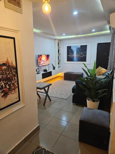una sala de estar con un sofá y una mesa en Mohills Apartment, en Abuja