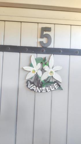 a number sign on a garage door with flowers at Maison cosy à Ravine des Cabris avec piscine partagée in Ravine des Cabris