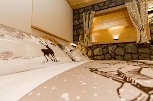a bedroom with a bed with a rock wall at Hotel Al Foiron in Claviere