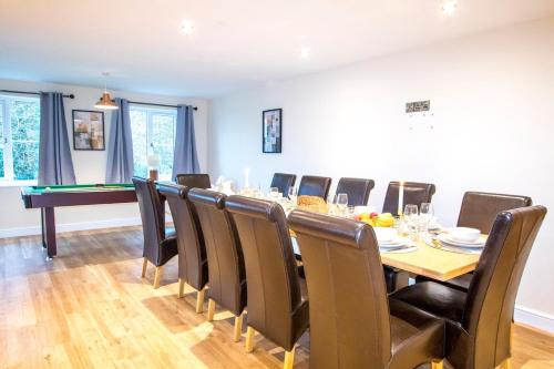 a dining room with a table and chairs and a pool table at Gym I Cinema I Hot tub I Games room at Copper Beech in Shrewsbury