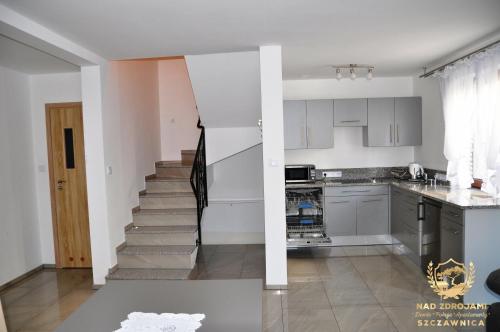 a kitchen with white cabinets and a stairway at "Nad Zdrojami" Domek Kowalczyk in Szczawnica
