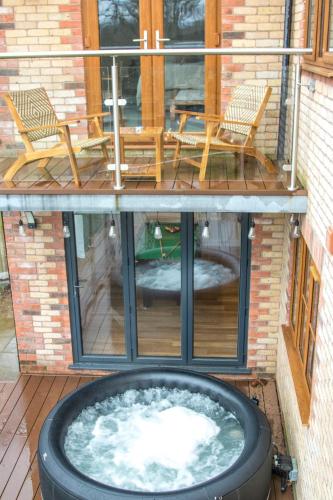 a patio with chairs and a hot tub on a deck at Gym I Cinema I Hot tub I Games room at Copper Beech in Shrewsbury