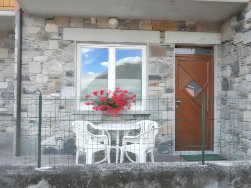 a table and chairs in front of a house with a window at Charming apartment in Livo 70 m² with mountain view in Livo