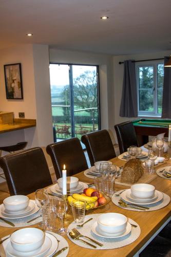 a table with plates and glasses and a candle on it at Gym I Cinema I Hot tub I Games room at Copper Beech in Shrewsbury