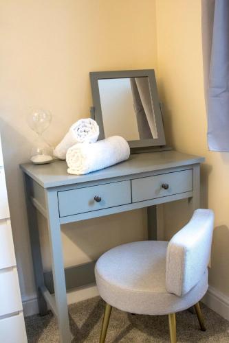 a dressing table with a mirror and a stool at Gym I Cinema I Hot tub I Games room at Copper Beech in Shrewsbury
