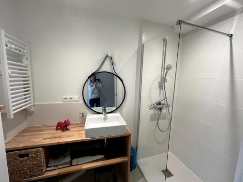 a person taking a picture of a bathroom with a mirror at TY BIHAN Plage à 300m Bourg 500m in Piriac-sur-Mer
