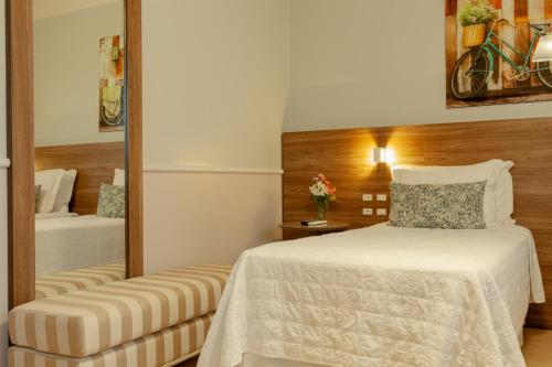 a hotel room with a bed and a mirror at Hotel Casacurta in Garibaldi