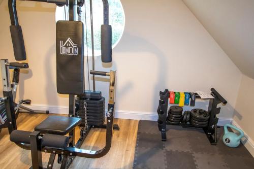 a room with a gym with a treadmill at Gym I Cinema I Hot tub I Games room at Copper Beech in Shrewsbury