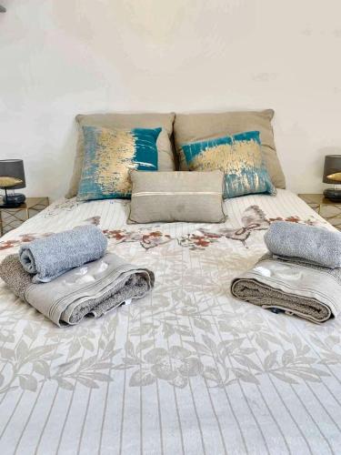 - un lit avec des serviettes et des oreillers dans l'établissement Appartement charmant avec jacuzzi à La Ciotat, 48m², à La Ciotat