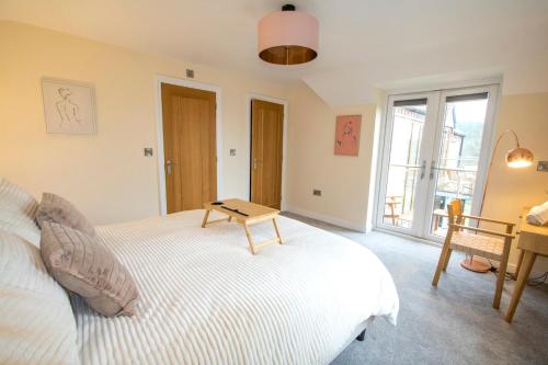 a bedroom with a bed with a table on it at Gym I Cinema I Hot tub I Games room at Copper Beech in Shrewsbury