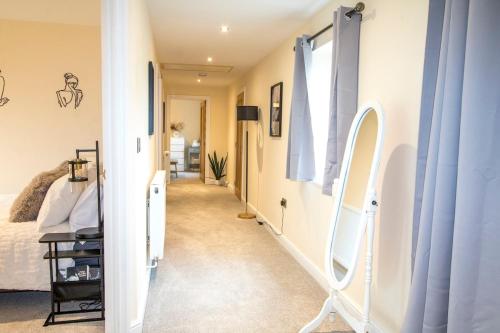 a hallway with a mirror and a bed at Gym I Cinema I Hot tub I Games room at Copper Beech in Shrewsbury
