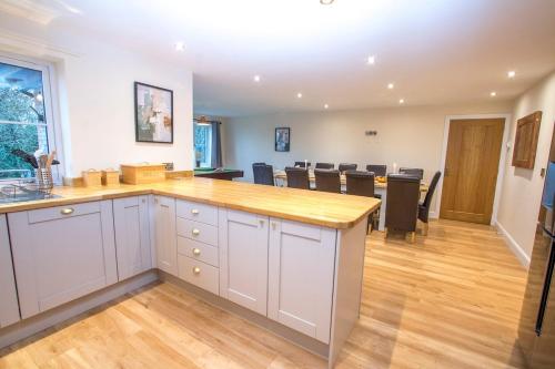 a kitchen with a counter and a dining room at Gym I Cinema I Hot tub I Games room at Copper Beech in Shrewsbury