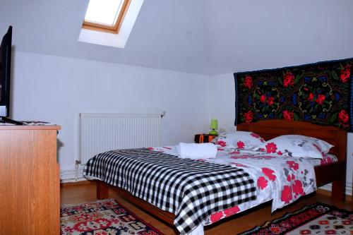 a bedroom with a bed with a black and white blanket at Pensiunea Inima Maramureșului in Breb