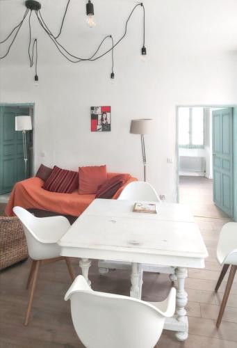 - une table et des chaises blanches dans une chambre avec un lit dans l'établissement Appartement charmant à Algajola avec terrasse, à Algajola