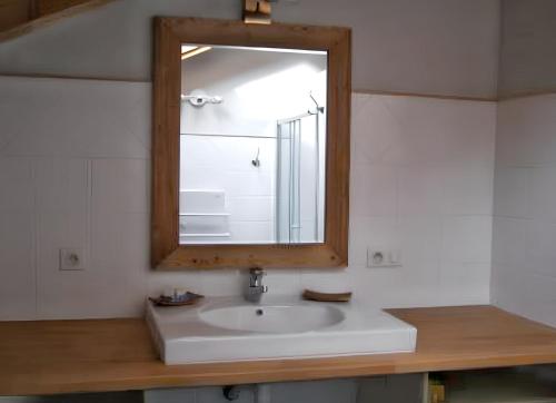 une salle de bain avec un lavabo blanc et un miroir dans l'établissement Appartement cosy à Samoëns avec jacuzzi, à Samoëns