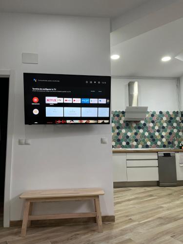 a wall with a bench and a tv on a wall at Apartamentos VALDECILLA nuevos in Santander