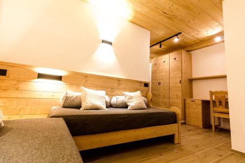 a bedroom with a bed in a room with wooden walls at Hotel Al Foiron in Claviere
