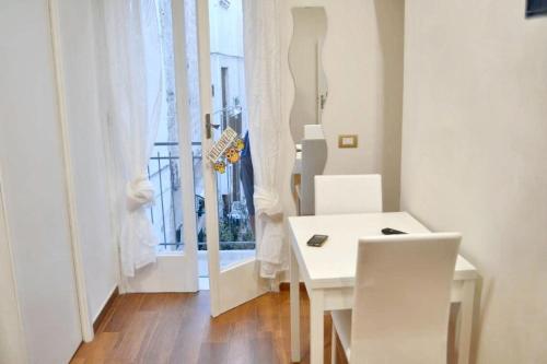 a white table and chairs in a room with a window at Charming apartment in Polignano a Mare with terrace. in Polignano a Mare