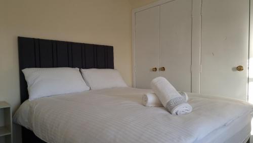 a white bed with two rolled towels on it at Ye Olde Hotel in Leuchars