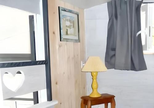 une lampe assise sur une table à côté d'une fenêtre dans l'établissement Maison charmante à La Rochelle avec jardin, à La Rochelle