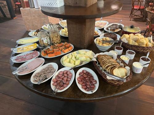 a table with a bunch of different types of food at Paraíso Enxaimel Mundo Antigo in Pomerode