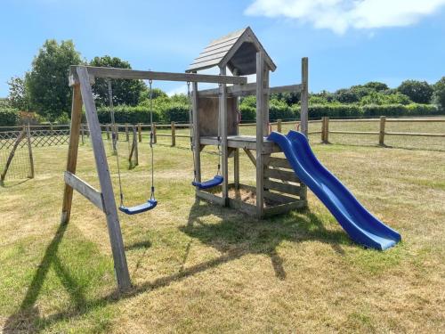 a playground with a blue slide and a swing at Maison cosy à La Bouillie + jardin in La Bouillie
