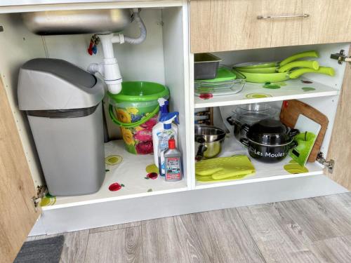 a kitchen cabinet filled with lots of kitchen items at Maison cosy à La Bouillie + jardin in La Bouillie