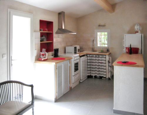 Il comprend une cuisine équipée d'un réfrigérateur blanc et d'une cuisinière. four supérieur dans l'établissement Maison charmante avec jacuzzi et vue sur montagne à Sartène, à Sartène