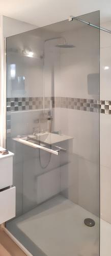 une douche en verre dans une salle de bain avec un lavabo dans l'établissement Maison charmante à Colleville-Montgomery avec jardin clos, à Colleville-Montgomery