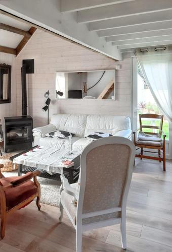 un salon avec un canapé et une table dans l'établissement Maison charmante à Colleville-Montgomery avec jardin clos, à Colleville-Montgomery