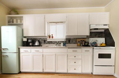 a kitchen with white cabinets and a white refrigerator at Sunrise and Bayview with SNOW SHOES, WATERCRAFTS , BIKES in Meaford
