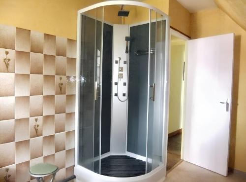 a shower with a glass door in a bathroom at Maison confortable à Saint-Laurent-de-Cuves avec jardin in Saint-Laurent-de-Cuves