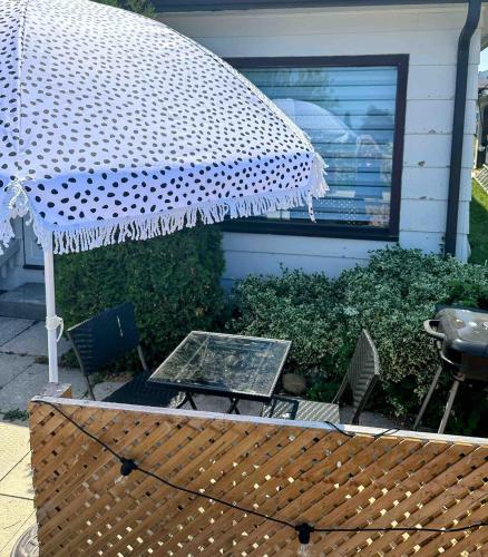 a patio with a table and an umbrella at Sunrise and Bayview with SNOW SHOES, WATERCRAFTS , BIKES in Meaford