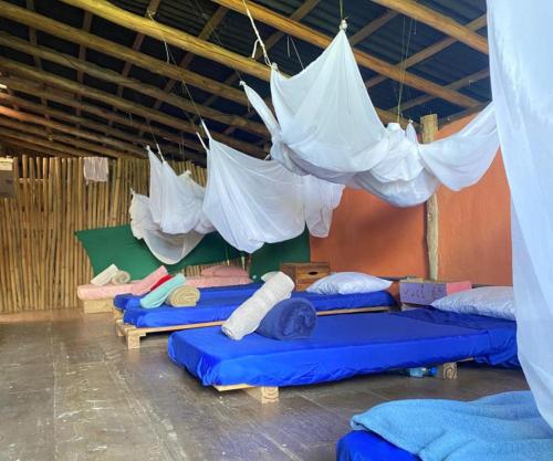 a room with a bunch of beds with umbrellas at Remo Hostel in Parati-Mirim