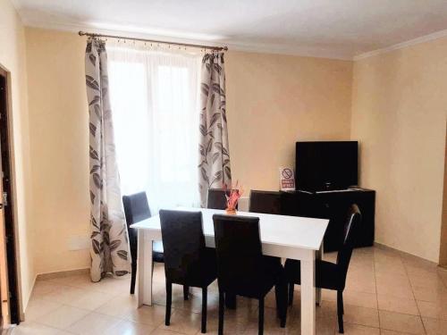 a dining room with a table and chairs and a window at Charming House in Săcele with Garden View + BBQ in Săcele