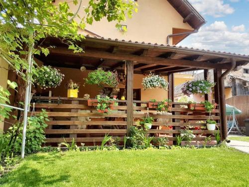 a wooden fence in front of a house with potted plants at Charming House in Săcele with Garden View + BBQ in Săcele