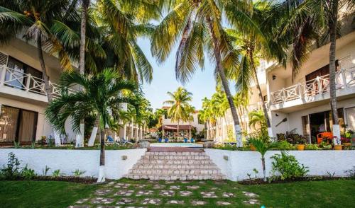 a resort with palm trees and a walkway at Idyllic Beachfront Condo in Ocho Rios