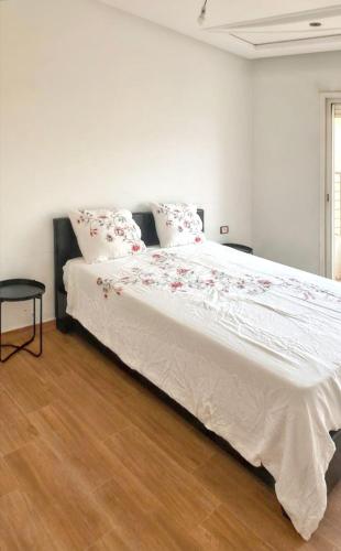 a bedroom with a large white bed with red flowers on it at Spacious apartment in Nouaseur of 167 m² in Nouaseur