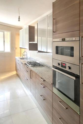 a kitchen with stainless steel appliances and wooden cabinets at Spacious apartment in Nouaseur of 167 m² in Nouaseur