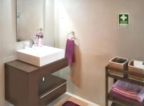 un bagno con un lavandino bianco e uno specchio di Modern Apartment in Lagos + Pool a Lagos